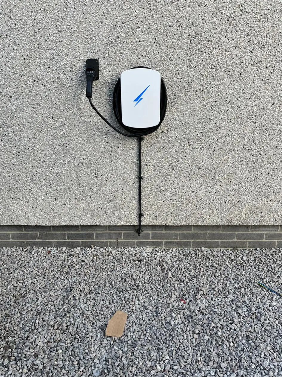 Wall-mounted EV charge point on a harled wall