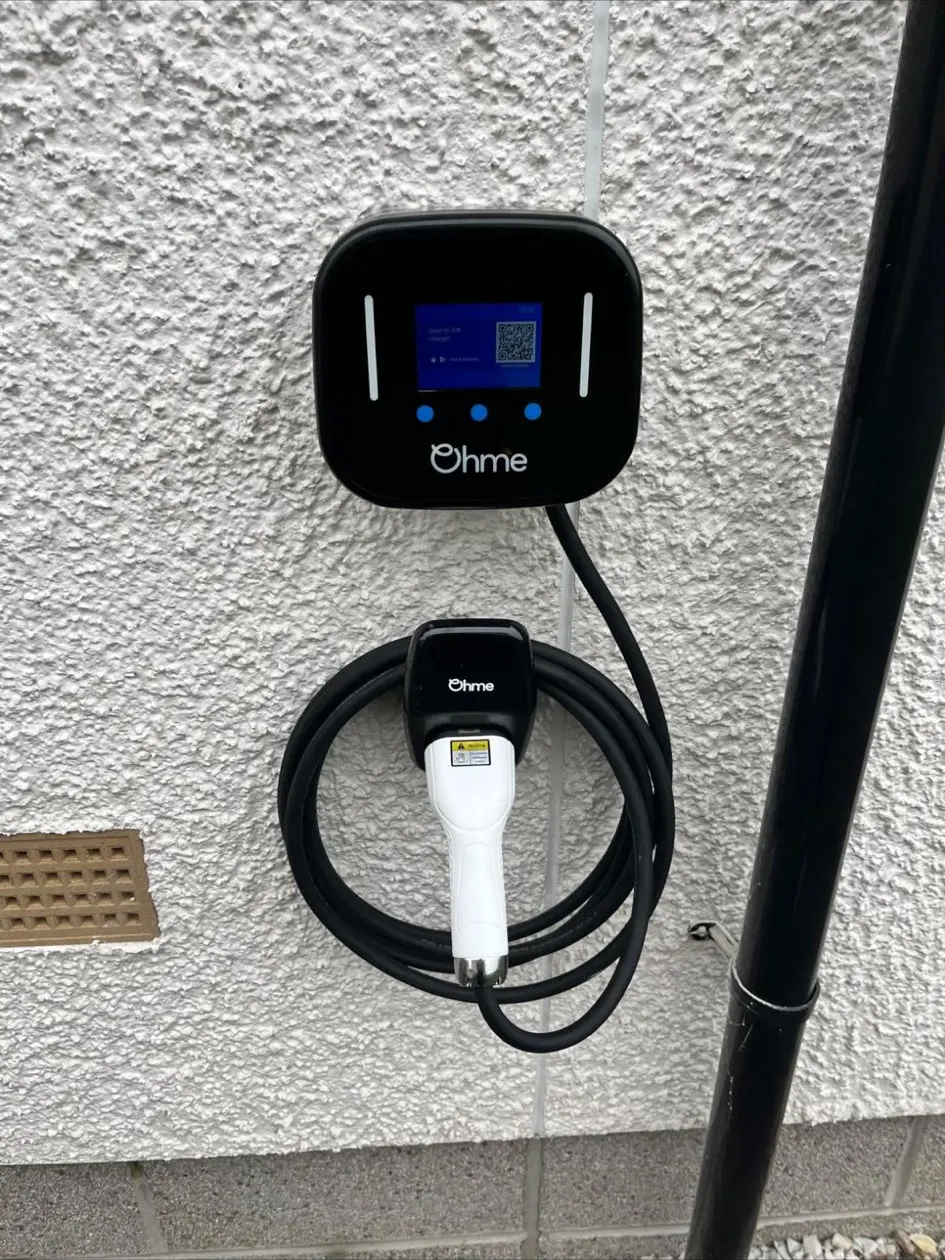Ohme Home Pro charger installed on roughcast render