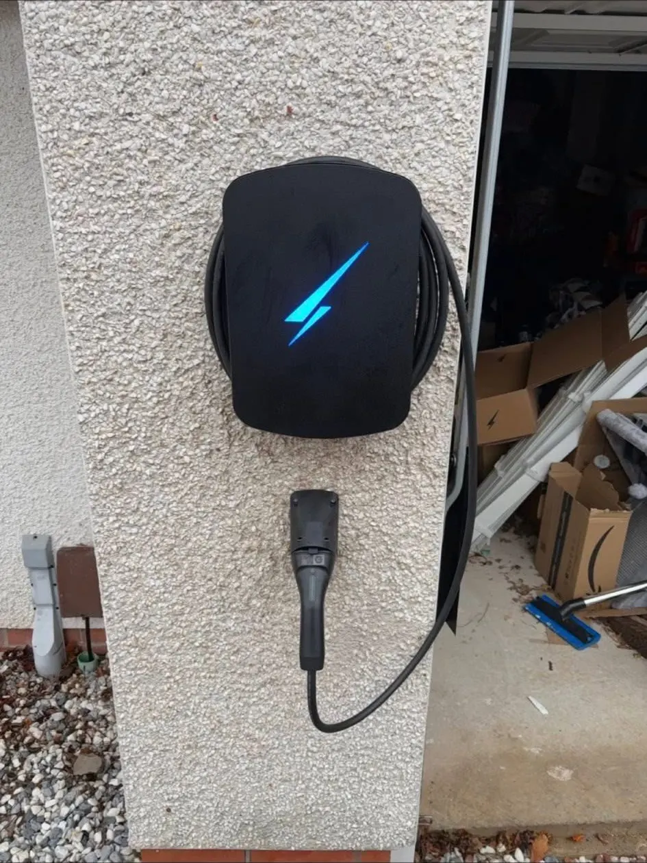 EV charger with illuminated status light at dusk