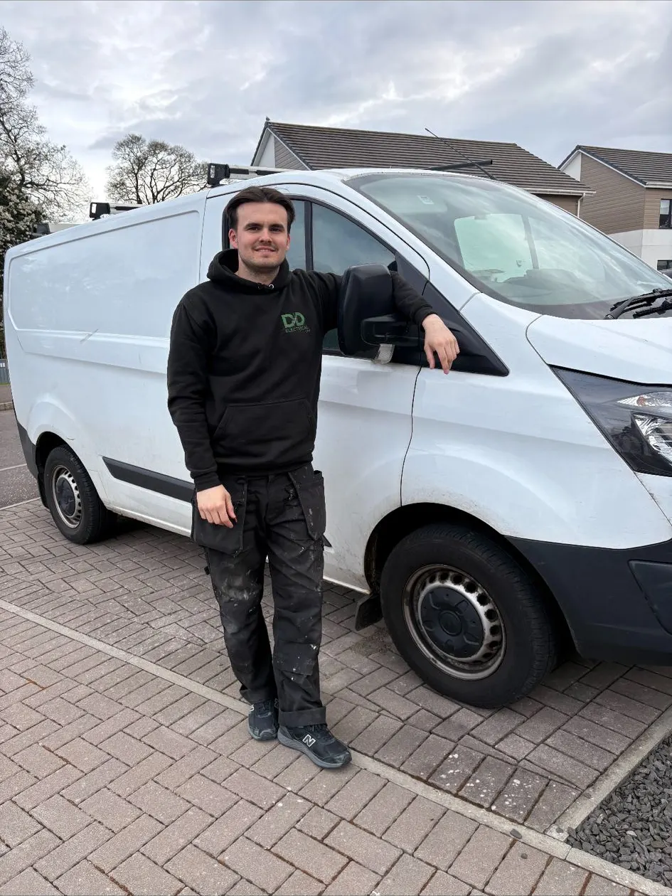 Matthew from DD Electrical standing beside the company van in Dundee