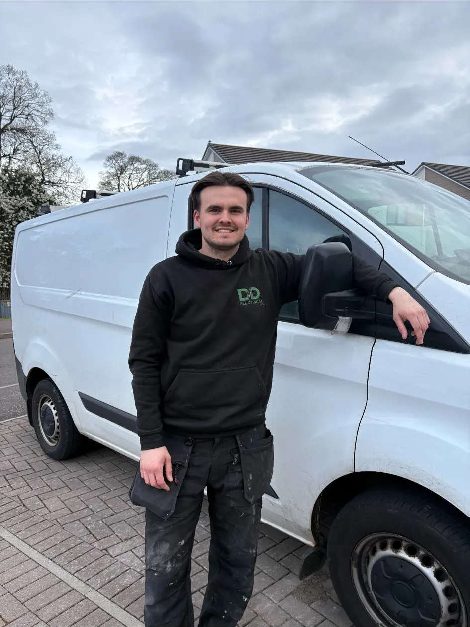 Matthew from DD Electrical in branded workwear beside the company van